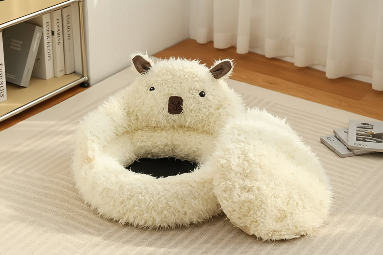Fluffy white animal-shaped pet bed on a wooden floor